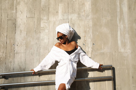 Gorgeous African American young woman wrapped in white towel posing outdoor.の写真素材