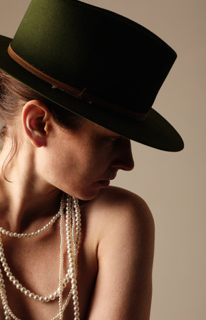 Vertical portrait of confident young woman wearing green hat posing indoor.の写真素材