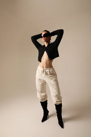 Studio portrait of confident young woman wearing sunglasses posing indoor.の写真素材