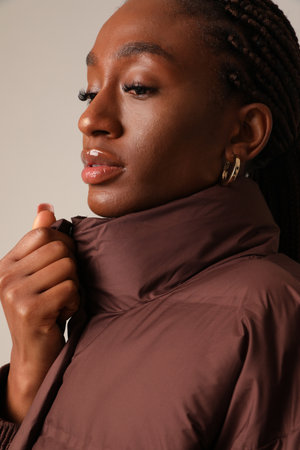 Warm and comfy. Young fashionable woman wearing down jacket. Vertical mock-up.の写真素材