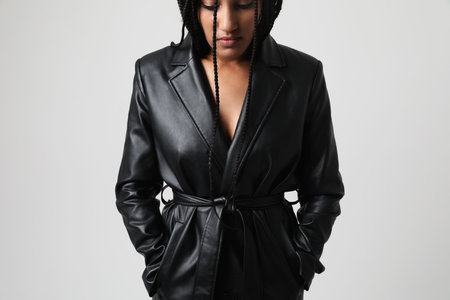 Young African American woman wears leather jacket posing indoor. Mock-up.の写真素材