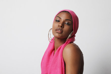 Beautiful young woman with traditional turban posing on white wall. Horizontal.の写真素材