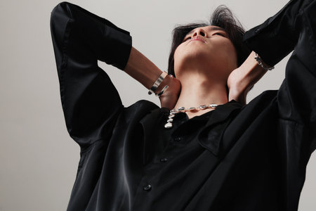 Cropped portrait of young man with earrings posing over white wall. Mock-up.の写真素材