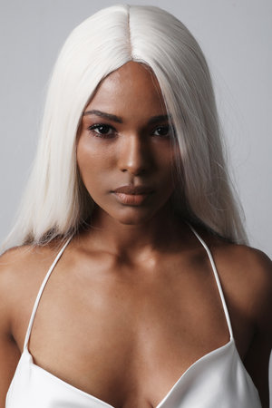 Portrait of young woman with long blonde hair posing indoor. Vertical mock-upの写真素材