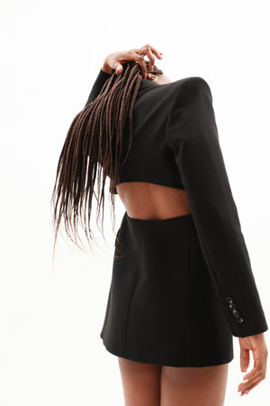 Back view of young woman. Posing over white background looking away. Vertical.の写真素材