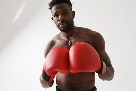 African American Athletic man with good body condition boxing with red gloves.の写真素材