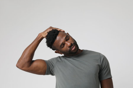 African American athletic man doing neck stretching exercises. Mock-up.の写真素材