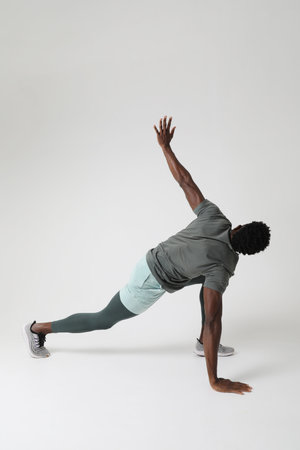 Athletic young man doing muscle intense exercises indoor. Vertical mock-up.の写真素材