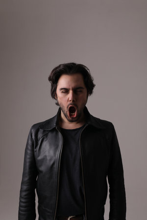 Handsome young man making face grimace isolated on white wall. Vertical mock-up.の写真素材