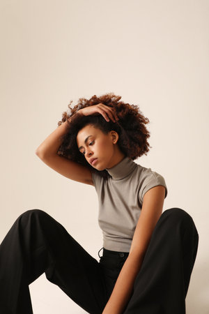 Beautiful African American young woman with curly hair posing indoor. Vertical.の写真素材