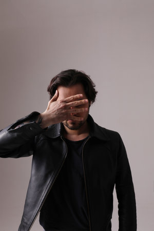Close-up of handsome man showing his hands isolated on white wall. Mock-up.の写真素材