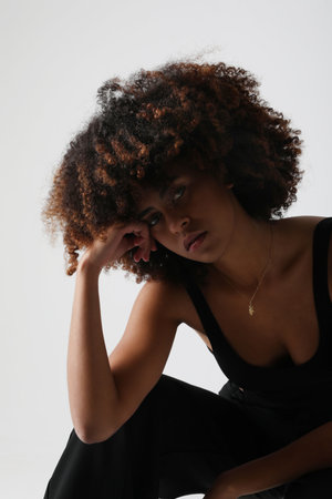Indoor portrait of African American young woman with curly hair. Mock-up.の写真素材