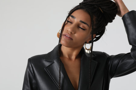 Close-up of African American young woman with long braids, posing at studio.の写真素材