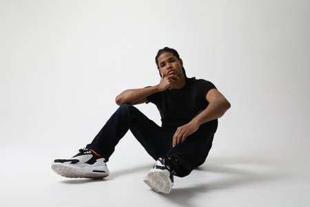 Portrait of stressed dark-skinned young man posing in the studio. Mind-set.の写真素材