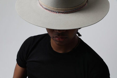 Close-up of handsome dark-skinned young man wearing trendy hat. Isolated.の写真素材