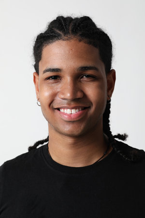 Smiling handsome dark-skinned young man posing in the studio. Vertical.の写真素材