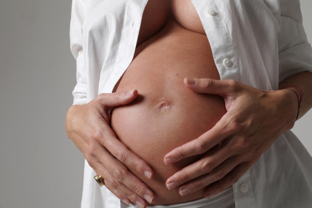 Vertical portrait of woman on second trimester of pregnancy. Close-up.の写真素材