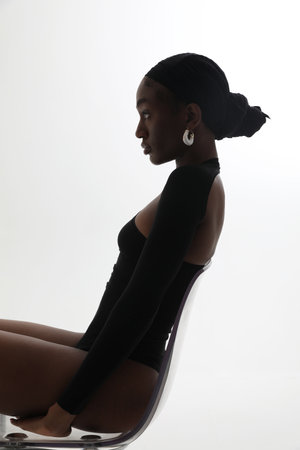 Vertical portrait of young African American woman posing on white background.の写真素材