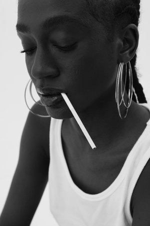 Black and white close-up portrait of young African woman, wearing big hoops.の写真素材