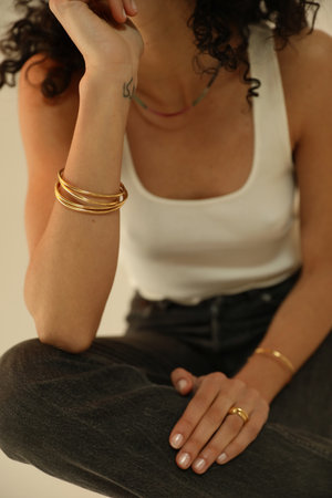 Close-up portrait of woman with a healthy skin wearing golden jewellery.の写真素材