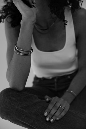 Black and white close-up portrait of woman wearing golden jewellery. Vertical.の写真素材