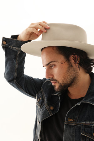 Portrait of Caucasian handsome man on white background wearing hat looking away.の写真素材