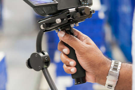 afroamerican hand holding a stabilizer and recorgding to footageの写真素材