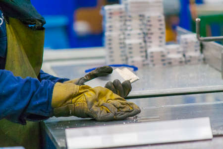 Hands with gloves holding wellow thin core of aluminum alloyの写真素材