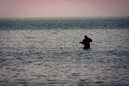 Some man fishing in the middle of the sea
