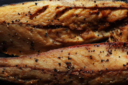 Photography of two fillets of smoked mackerel with ground black pepper for food illustrations