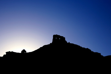 Ancient Egyptian temple silhouetted against a vivid blue sky at sunsetの写真素材