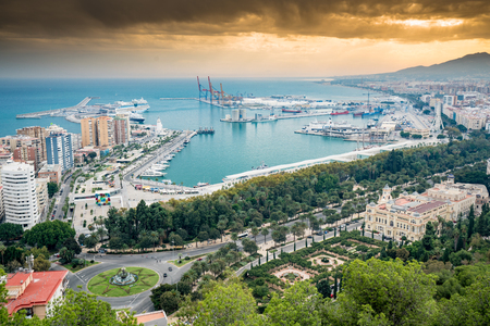 malaga port with cruise ship in dock and dramatic sky with blue seaの写真素材