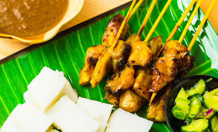 Chicken satay with cubic rice, atjar and curry bean sauce. Tradition food in Thailandの写真素材