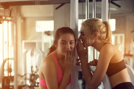 Two beautiful women discuss after exercise at the gymの写真素材