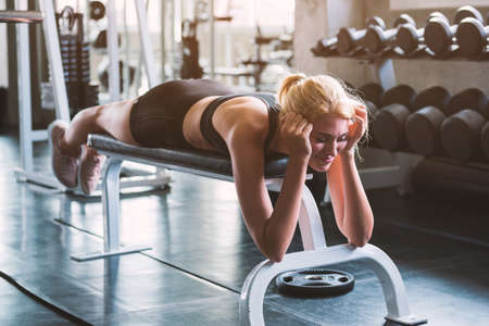 A young woman rest on the chair after trainning at the gym