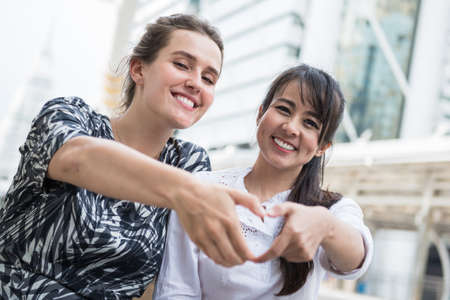 Love in the air, young women making heart symbol with fingerの写真素材