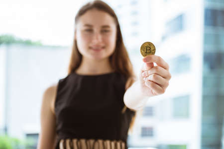 Beautiful woman holding bitcoin cryptocurrency in her hand