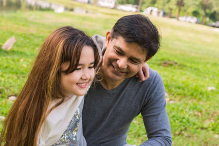 A little daughter smile and play with her father in the park, family conceptの写真素材