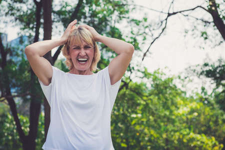 Senior woman screaming in the parkの写真素材