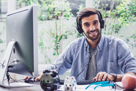 Confident young man working and concentrate on monitor while sitting at his working place in office