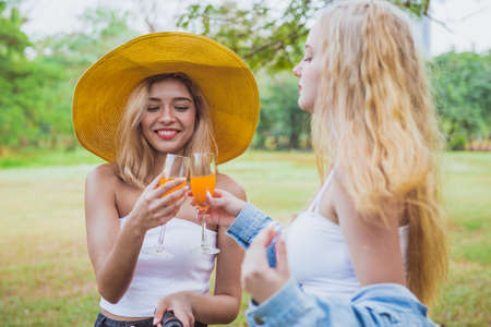 Beautiful girl serve a juicy to her friends after ride a bicycleの写真素材