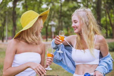 Young beautiful woman serve a juicy to her friends after ride a bicycleの写真素材
