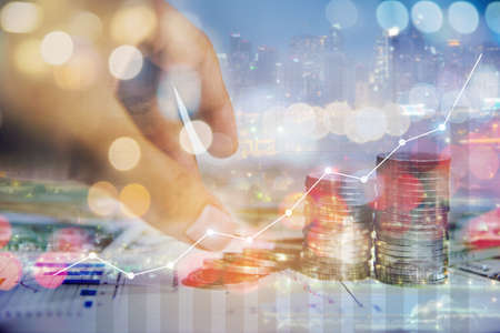 Double exposure of graph and rows of coins for finance and business investement conceptの写真素材