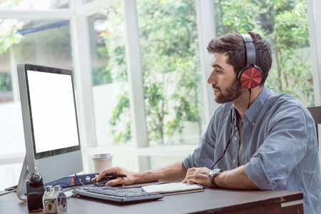 Confident young man working and concentrate on monitor while sitting at his working place in office