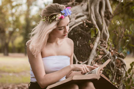 Beautiful woman reading a book in the parkの写真素材