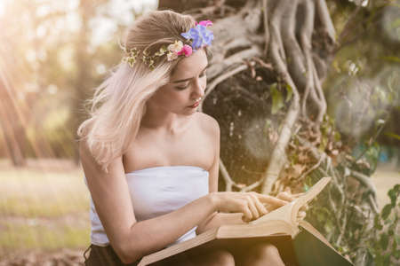 Beautiful woman reading a book in the parkの写真素材