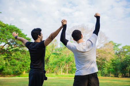 Men feeling cheerful and hand up in the park