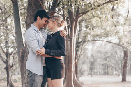 Young couple in love, hugging under the treeの写真素材