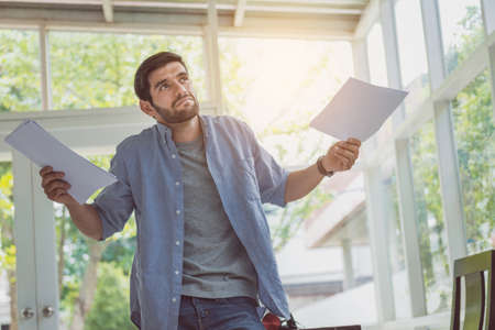 Smart man thinking after review document at home office.の写真素材