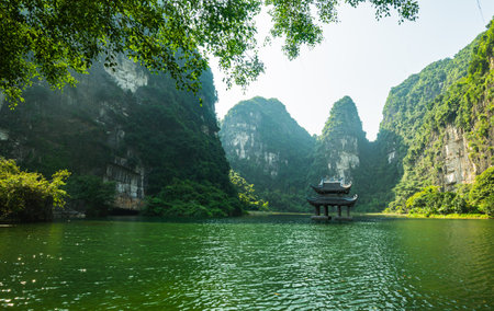 Sacred temple in the middle of the river, surrounding by limestone cliffの写真素材